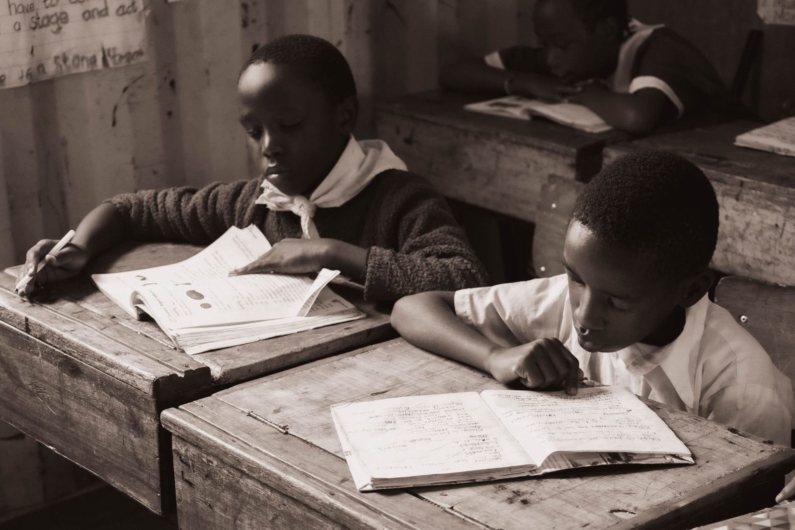 Student writing at a desk, focused on their work