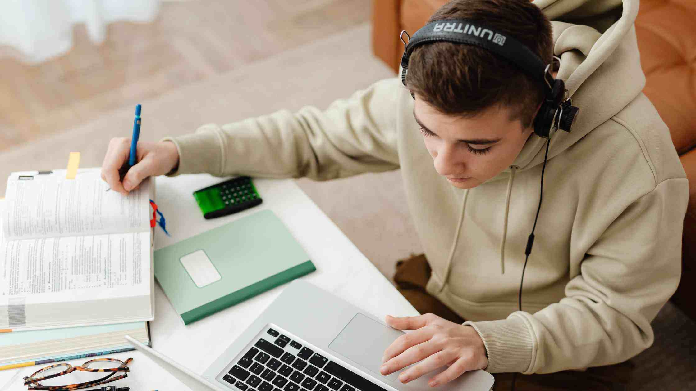 Student studying with laptop, & textbooks, representing flexible online SAT coaching options tailored to different learners.
