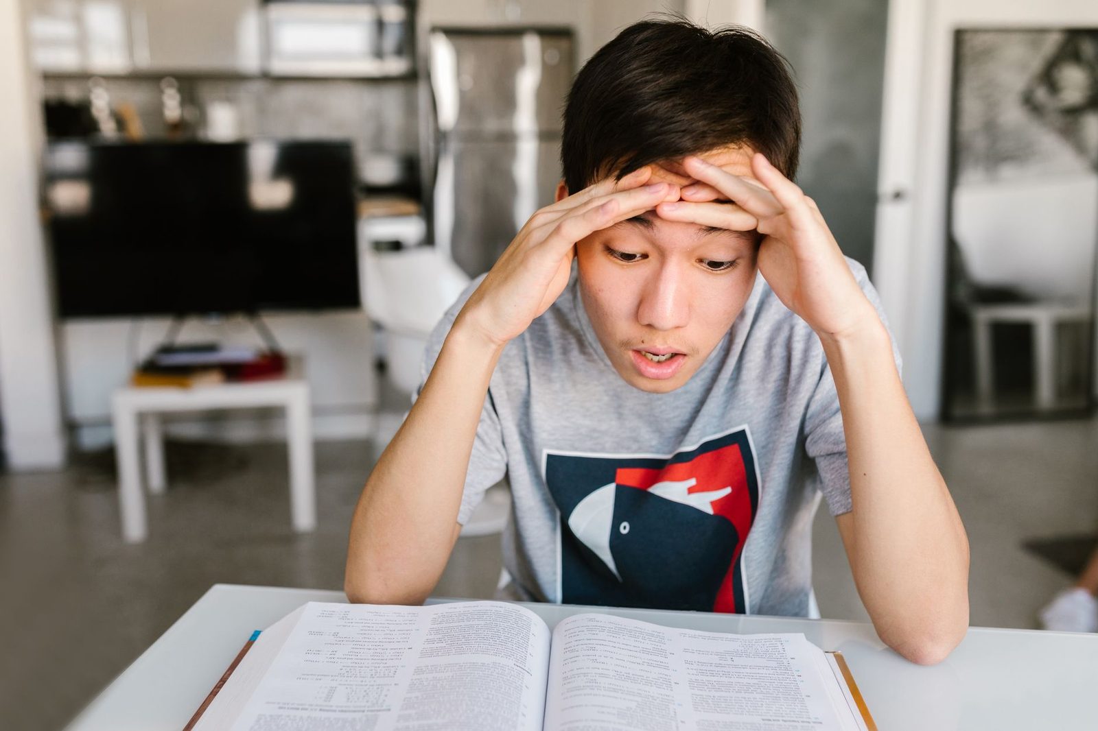 Student looking frustrated while studying math at a desk