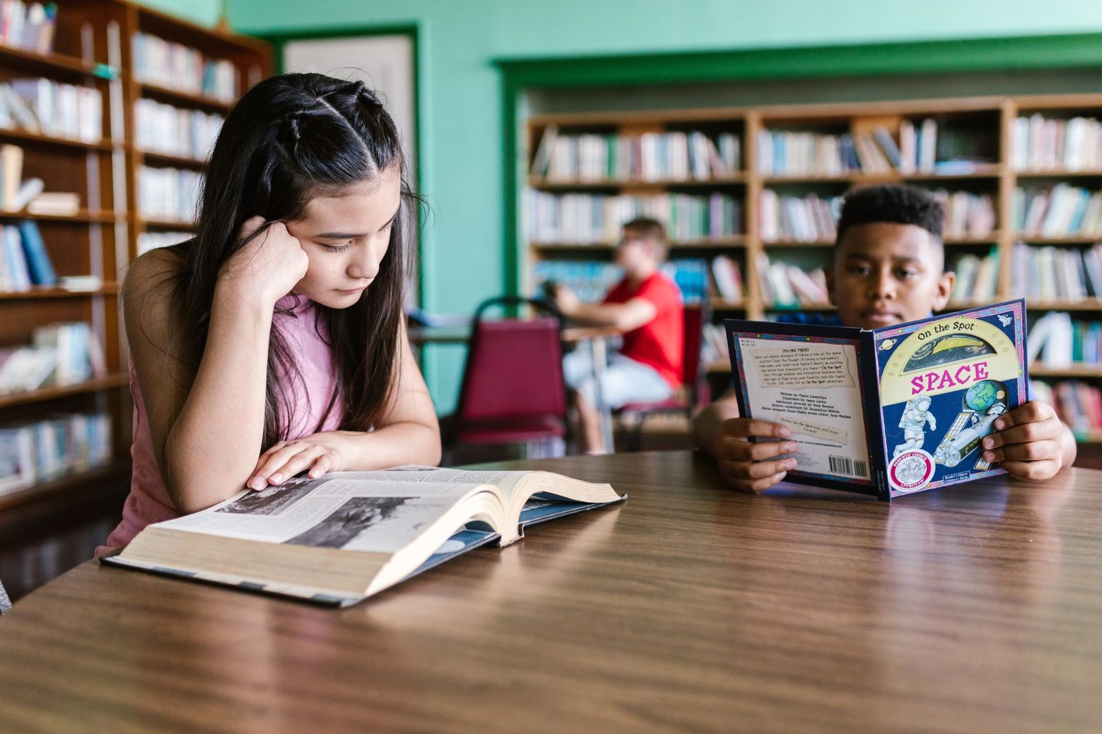 High school student reading a book at a desk